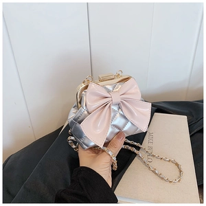 Détail du mini sac argenté matelassé avec nœud rose et fermoir en métal doré