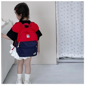 Close-up of kids backpack with red and blue contrast and cute cartoon ear detail