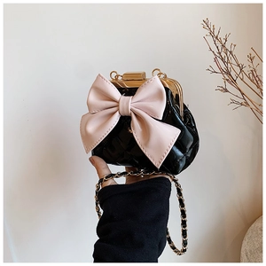 Détail d'un sac pour fille matelassé noir avec nœud rose et fermoir en métal doré