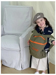 Vue détaillée du sac à dos enfant vert olive avec fermetures éclair orange vif