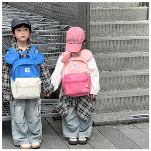 Detail view of colorful children's backpacks with round ears and logo patch