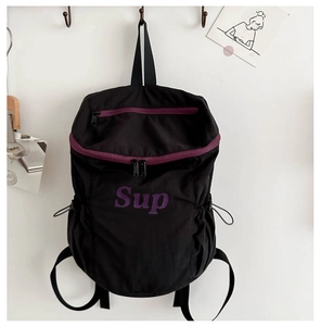 Détail d'un sac à dos de sport noir avec zips violets et cordons de serrage latéraux