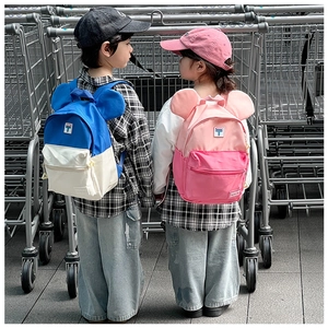 Detail view of colorful kids backpack with cute round ears in an outdoor shopping scene