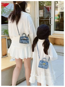 Détail de mini sacs bandoulière en denim avec fermoir rotatif pour mère et enfant