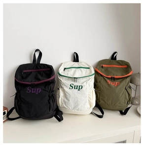 Vue détaillée de trois sacs à dos pour enfants en noir, blanc et vert avec logo Sup