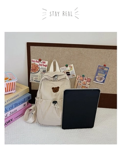 Détail du sac à dos enfant en toile beige avec broderie ours et poche à cordon de serrage