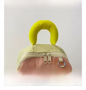 Detail of pink and yellow kids backpack showing padded handle and double zippers