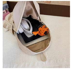Détail intérieur du sac à dos beige montrant la grande capacité pour ordinateur et accessoires