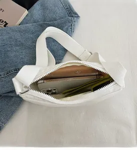 Detailed interior of a white canvas crossbody bag showing spacious storage for daily essentials