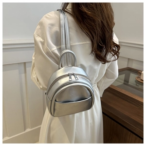 Detailed view of silver metallic mini backpack for kids featuring double zippers