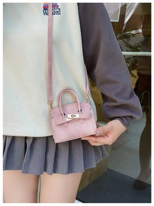 Détail du mini sac bandoulière rose avec fermoir rotatif en métal et texture fine