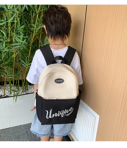 Detailed back view of a black and beige school backpack with Unique embroidery and Fashion logo