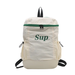 Sac à dos enfant blanc cassé avec lettrage vert et fermetures éclair contrastées