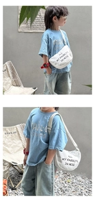 Detail of kids white canvas crossbody bag with letter print and light blue cotton T-shirt