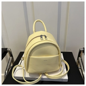 Close-up of cream yellow mini backpack with dual zippers and aimai brand logo detail