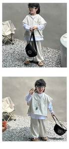 Detail of grey children vest and pants with smile print crossbody bag in outdoor setting