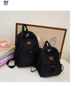 Détail de sacs à dos noirs pour enfants en deux tailles avec broderie ours mignonne