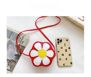 Detailed size comparison of a mini floral kids cross-body bag next to a mobile phone