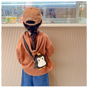 Rückansicht einer niedlichen Pinguin-Umhängetasche für Kinder mit braunem Hoodie