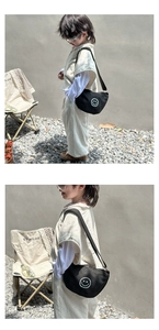 Close-up of children's crescent canvas crossbody bag with white smile embroidery