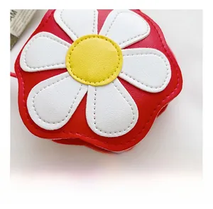 Detail view of the red flower-shaped crossbody bag with white petals and yellow center