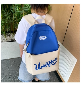 Detailed side view of large capacity two-tone school backpack worn by a child