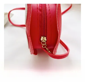 Detail view of red synthetic leather kids' flower bag with golden metal zipper and stitching