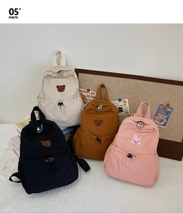 Vue détaillée de sacs à dos en toile en quatre couleurs avec broderies d'animaux
