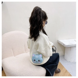 Detail of light blue cat-shaped crossbody bag worn by a girl in an aesthetic setting