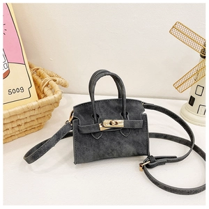 Détail du mini sac à main gris foncé texturé avec fermoir rotatif doré et bandoulière fine