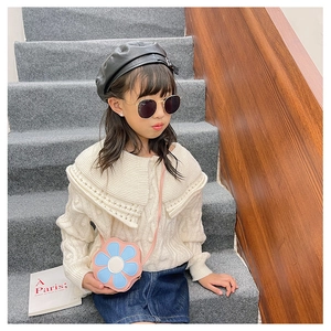 Detailed close-up of a floral-shaped PU crossbody bag with elegant knit sweater outfit