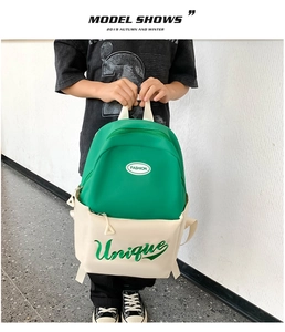 Detail of green and cream two-tone children backpack featuring Fashion and Unique embroidery