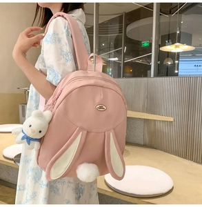 Close-up of pink bunny backpack featuring cute rabbit ears and soft plush tail detail