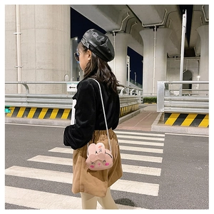 Detailed view of a pink bunny-shaped kids crossbody bag with a slim chain strap and carrot embroidery
