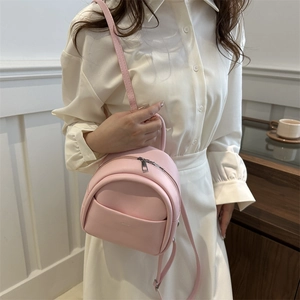 Pink faux leather mini backpack for kids with adjustable straps in a casual setting