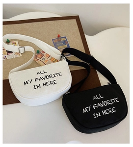 Detail view of half-moon canvas kids crossbody bags with smiley face and letter prints