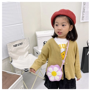 Detail of child wearing a knit cardigan, smile tee, and purple flower shoulder bag
