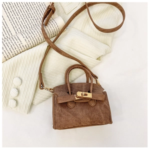 Détail d'un mini sac bandoulière marron avec texture sergée et fermoir doré chic