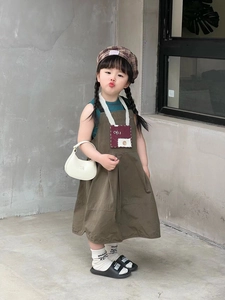 Fashionable young child street style outfit featuring a solid crossbody bag and beret hat