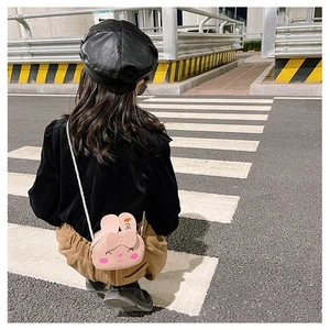 Detail of pink rabbit kids crossbody bag with 3D ears on a trendy outdoor model