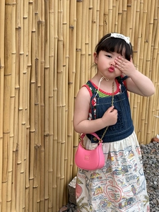 Pink mini leather chain bag for kids paired with a stylish denim map print dress