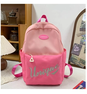 Detail of pink two-tone school backpack featuring Unique embroidery and side pocket