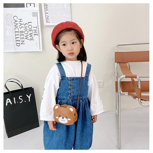 Detail shot of a cute brown bear leather crossbody bag on a child's denim dress outfit