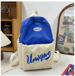 Blue and cream large capacity school backpack with fashion embroidery on a desktop