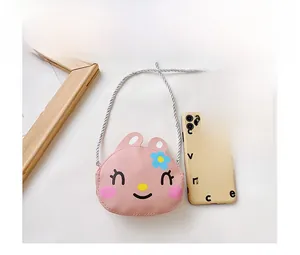 Mini pink rabbit crossbody bag shown next to a smartphone for size comparison