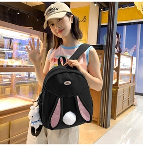Detail of black backpack featuring 3D rabbit ears and soft plush tail accessory