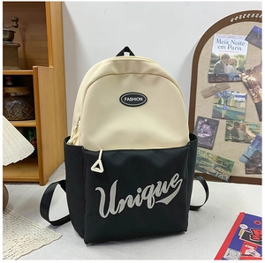 Detail of a beige and black school backpack with Unique embroidery and Fashion badge