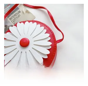 Detailed macro shot of a red leather daisy crossbody bag for kids with fine stitching