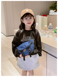Dettaglio del borsello in denim blu scuro per bambini con fibbie e tracolla regolabile