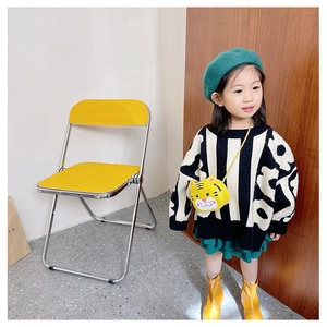Detail of child wearing a knit sweater with abstract print and yellow tiger crossbody bag